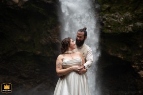 In Bajos del Toro, Costa Rica, the couple poses in front of a waterfall, with mist and lush greenery framing their elegant portrait in nature.